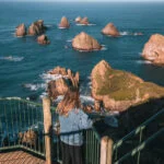 Person looking out at rocks in the ocean from Nugget Point Lighthouse